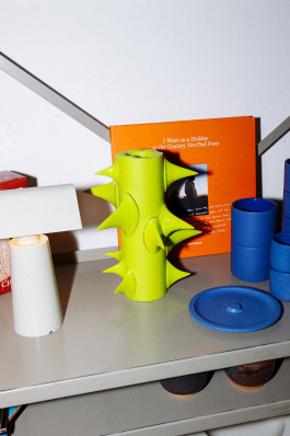 A light green vase standing in a shelf Logo Progressive Present