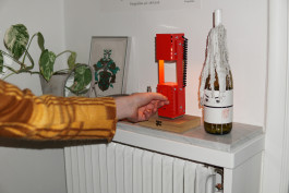 a red metal lamp standing on a sideboard Logo Progressive Present