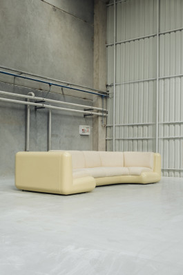 A white couch standing in a warehouse Logo Progressive Present
