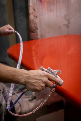 close-up of a hand painting a workpiece Logo Progressive Present