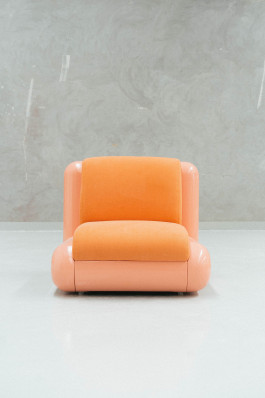 a rose chair standing on a neutral floor in front of a grey background Logo Progressive Present