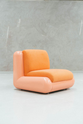 a rose chair standing on a neutral floor in front of a grey background Logo Progressive Present