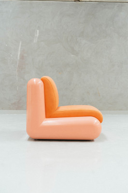 a rose chair standing on a neutral floor in front of a grey background Logo Progressive Present