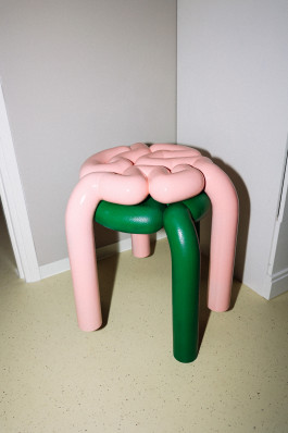 A pink and a green stool standing on the floor Logo Progressive Present