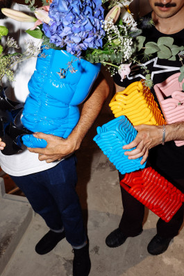 Two people holding various vases in blue, yellow and red color Logo Progressive Present