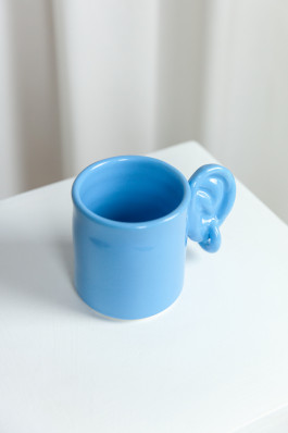 a blue stoneware mug standing on a white display Logo Progressive Present