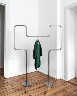 clothing on a silver metal clothes rack Logo Progressive Present