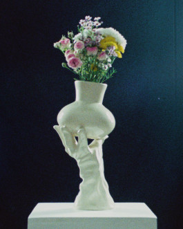 White glove-shaped vase standing on a display Logo Progressive Present