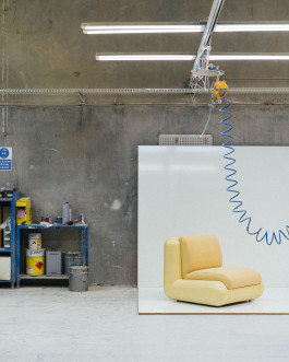 A white chair standing in a workshop Logo Progressive Present