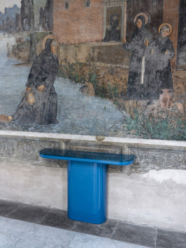 A blue sidetable standing on a wall Logo Progressive Present