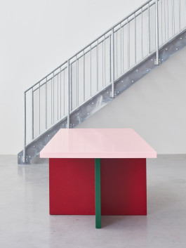 Tri-colored table standing in front of metal stairs Logo Progressive Present