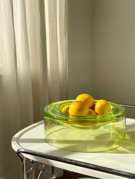 Photo of a glass bowl with lemons standing in front of a curtain. Logo Progressive Present