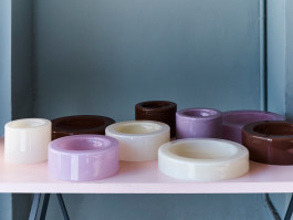 Various glass bowls in different sizes standing on a rose colored table. Logo Progressive Present
