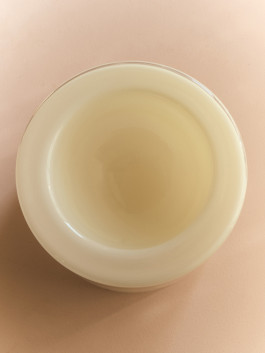 Beige glass bowl standing on a rose table. Logo Progressive Present