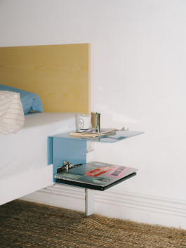 Minimalist floating bedside table, modern decor, and books next to a wooden headboard – contemporary bedroom design. Logo Progressive Present