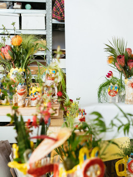 Colorful studio scene with handmade ceramic vases, tropical flowers, and vibrant artistic decor Logo Progressive Present