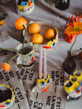 Creative table setting with handmade ceramic vases, colorful candles, and artistic home decor elements Logo Progressive Present