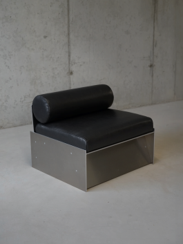 Modern lounge chair with cylindrical leather backrest and brushed steel base, minimalist design aesthetic Logo Progressive Present