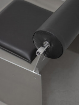 Close-up of adjustable cylindrical leather backrest and seat cushion on brushed stainless steel chair Logo Progressive Present
