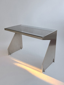 Minimalist desk with brushed metal frame and smoked glass top in modern lighting Logo Progressive Present