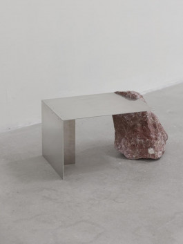 Minimalist side table with folded aluminum sheet supported by a raw natural stone on one side Logo Progressive Present