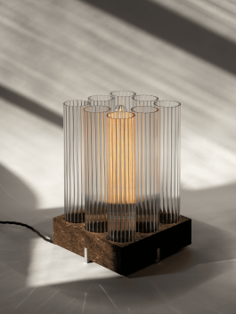 Sculptural table lamp made of ribbed glass and cork with warm interior lighting. Logo Progressive Present