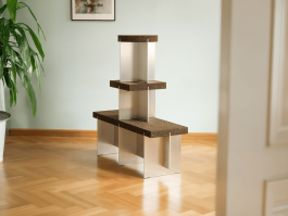 Stacked cork and aluminum elements forming a sculptural furniture piece by Robert Megel. Logo Progressive Present